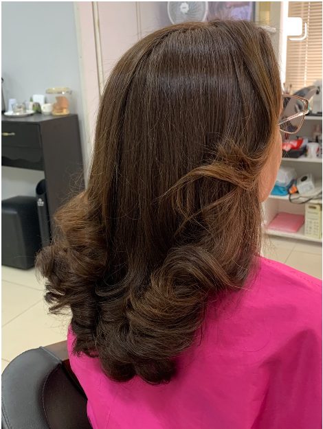 Escova modelada com cachos nas pontas em cabelo castanho